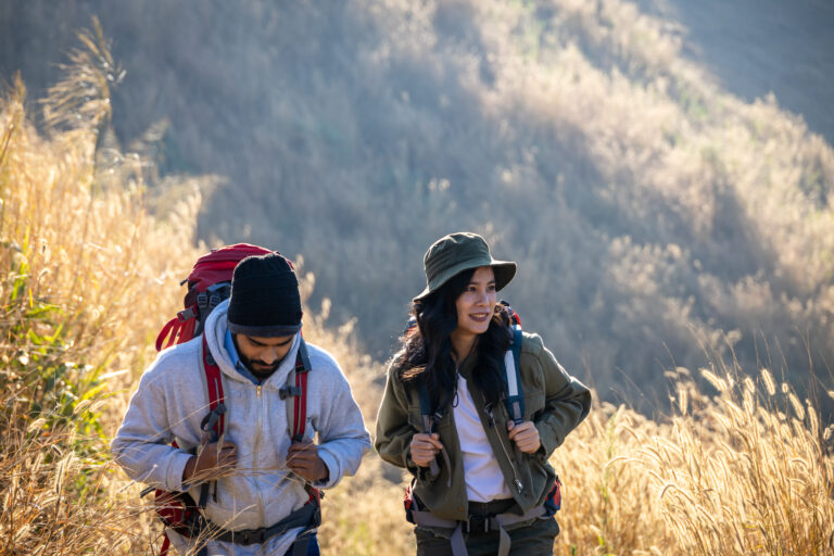 Happy Travelers Hiking with Backpacks on the Beautiful Rocky Tra